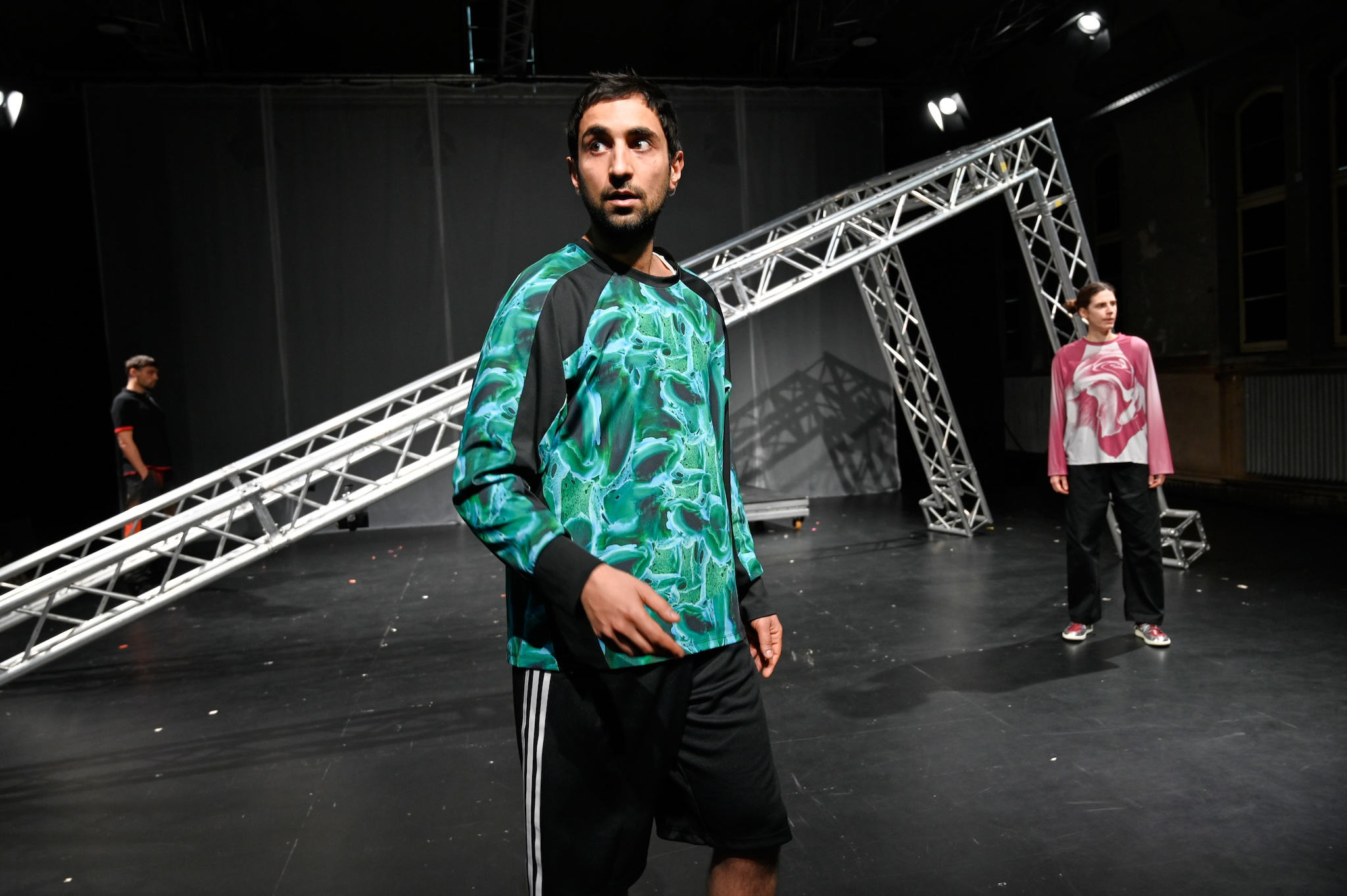 Drei Personen stehen um ein schräges Gerüst herum.