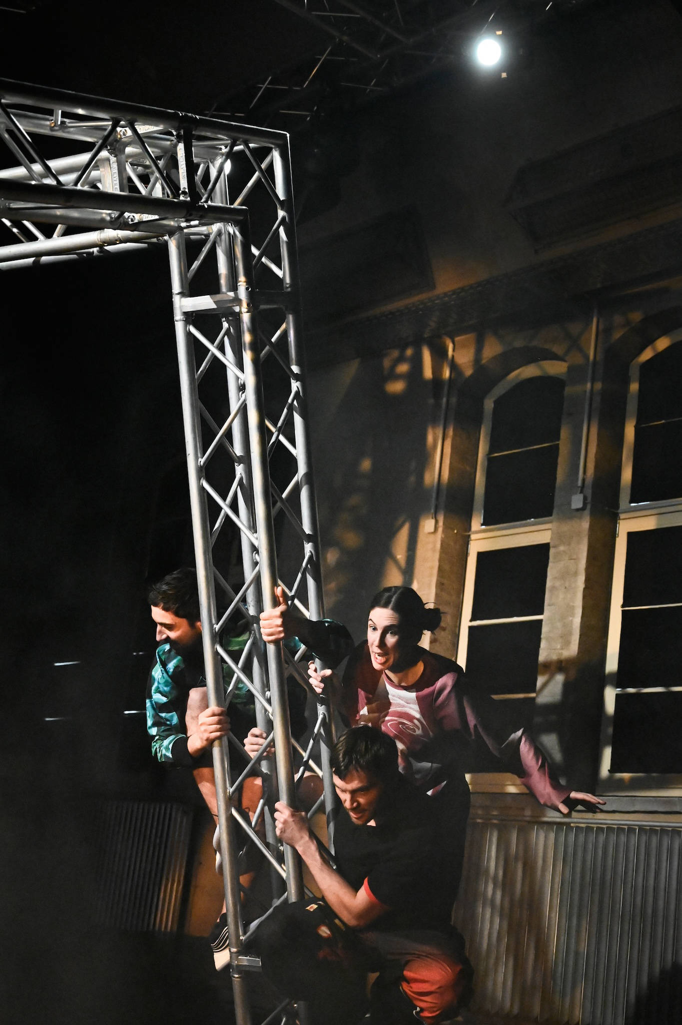 Drei Personen klettern auf einem Gerüst.